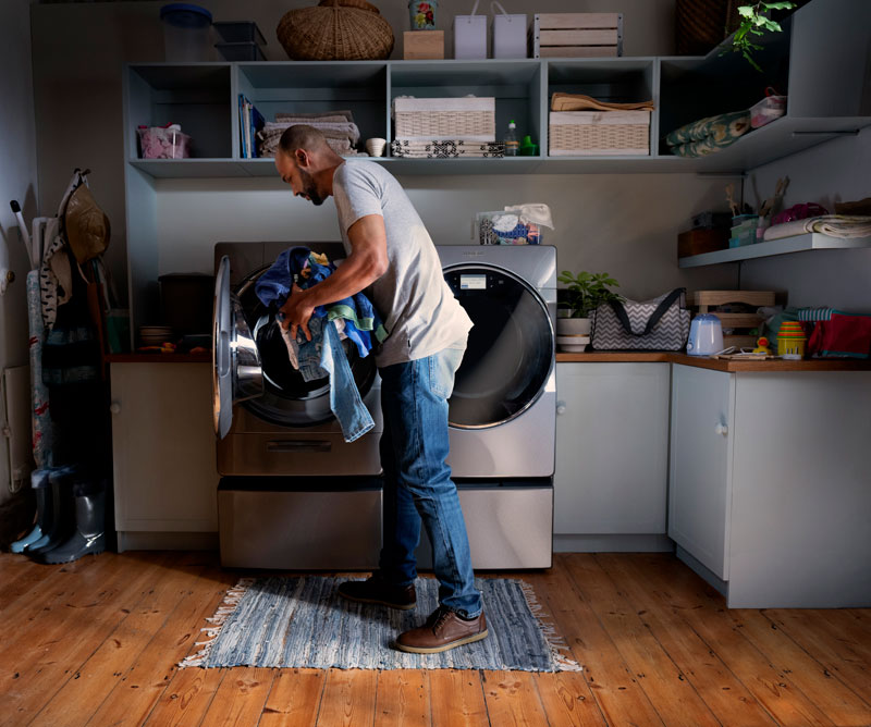 Whirlpool-brand-man-loading-dryer