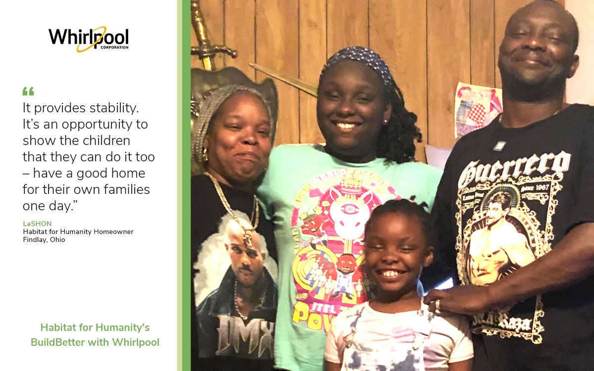 LaShon and family of Findlay Ohio proudly pose with all smiles in their wood-paneled home for a photo after moving into their Habitat for Humanity home. Their two teenage girls smile with LaShon and her husband.