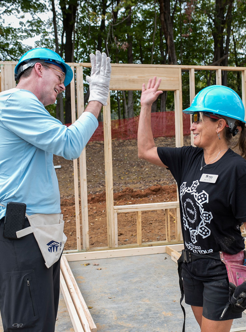 Jonathan Reckford and Whirlpool employee high five at an Indiana Habitat build